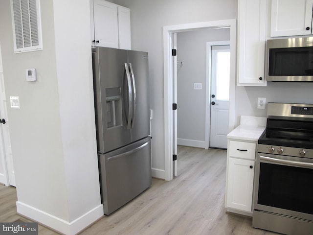 kitchen with white cabinetry, light countertops, light wood-style floors, visible vents, and appliances with stainless steel finishes