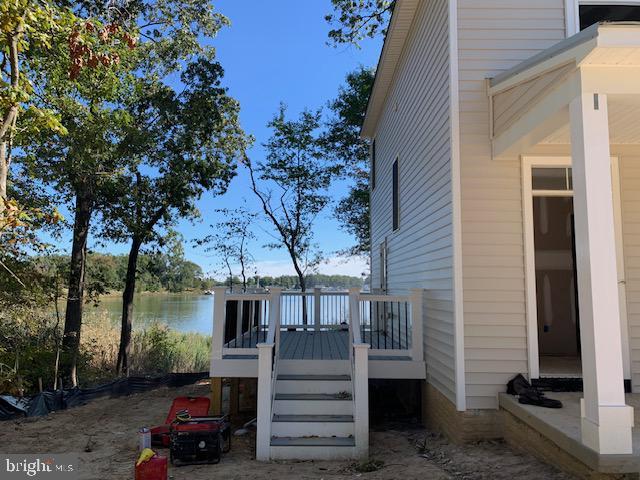 view of property exterior featuring a deck with water view and stairs