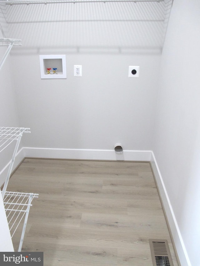 clothes washing area featuring hookup for a washing machine, baseboards, visible vents, electric dryer hookup, and wood finished floors