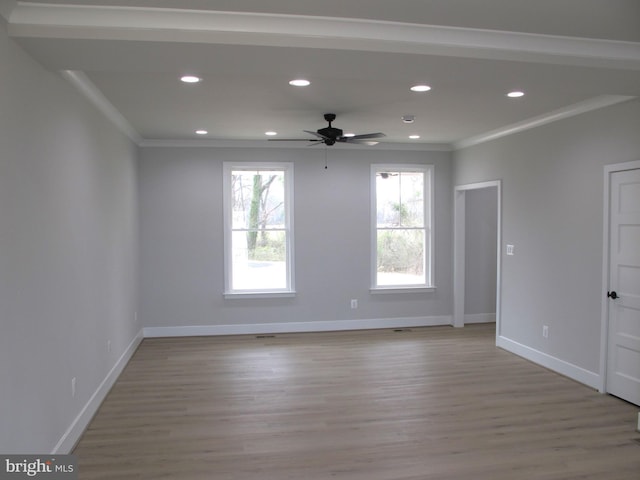 spare room featuring crown molding, recessed lighting, baseboards, a ceiling fan, and wood finished floors