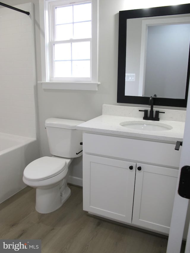 bathroom featuring toilet, vanity, and wood finished floors