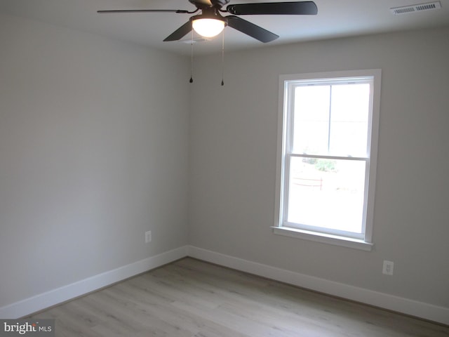 unfurnished room with light wood-type flooring, baseboards, ceiling fan, and visible vents