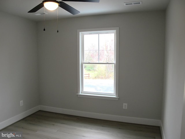 spare room featuring baseboards, visible vents, ceiling fan, and light wood-type flooring