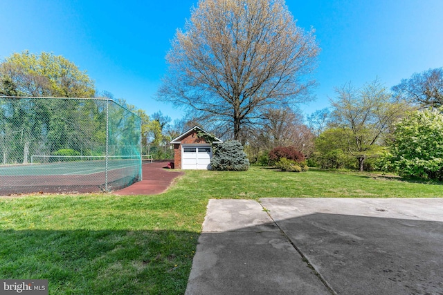 view of yard featuring fence and a tennis court