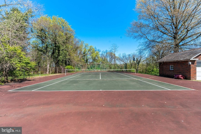 view of tennis court with community basketball court and fence