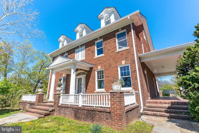view of front of house featuring brick siding and covered porch