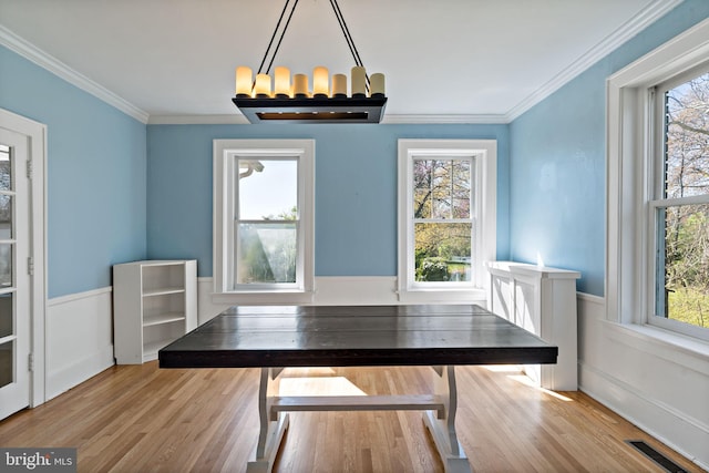 unfurnished dining area featuring wainscoting, wood finished floors, and visible vents