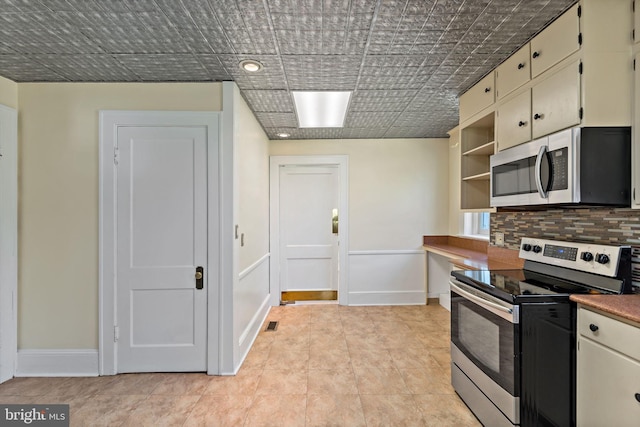 kitchen featuring open shelves, baseboards, appliances with stainless steel finishes, and tasteful backsplash