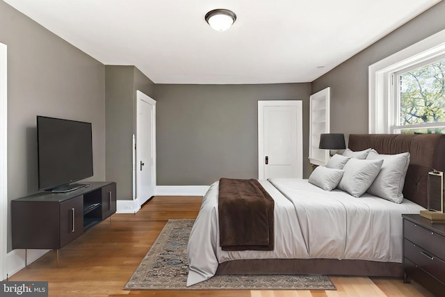 bedroom featuring baseboards and wood finished floors