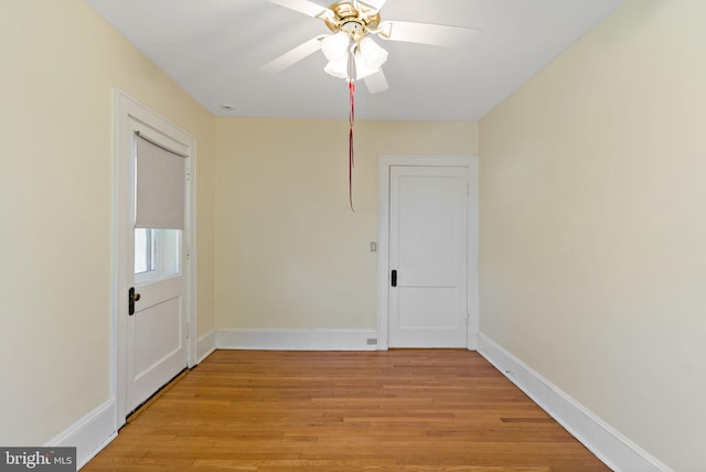 unfurnished room with baseboards, a ceiling fan, and light wood-type flooring
