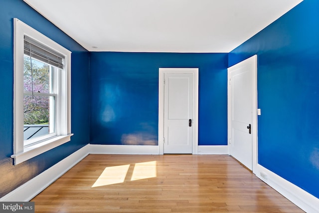 empty room with baseboards and wood finished floors