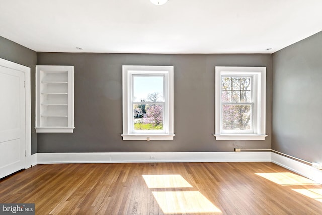 empty room with baseboards and wood finished floors