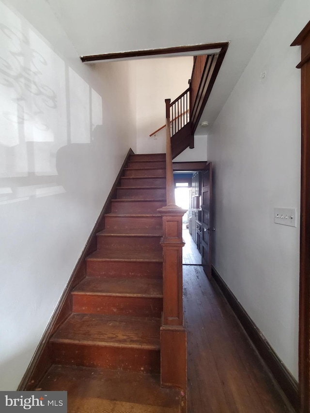 stairs with baseboards and wood-type flooring