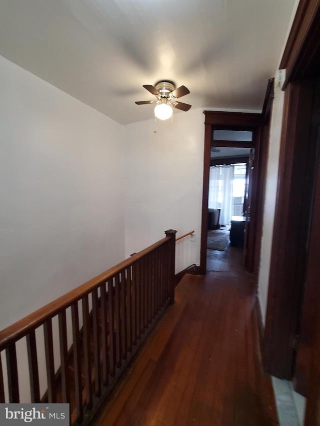 hallway with an upstairs landing and dark wood finished floors