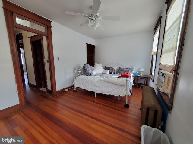 bedroom featuring baseboards, cooling unit, wood finished floors, and ceiling fan