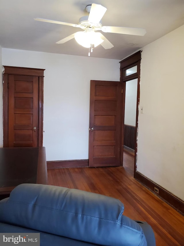 bedroom with baseboards, a ceiling fan, and dark wood-style flooring
