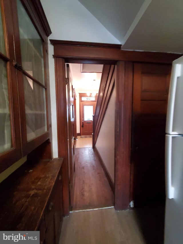 hallway featuring wood finished floors and vaulted ceiling