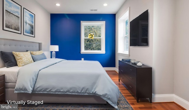 bedroom with recessed lighting, visible vents, baseboards, and wood finished floors