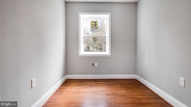 unfurnished room with wood finished floors and baseboards