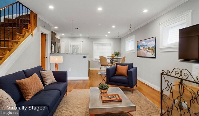 living area with crown molding, baseboards, wood finished floors, and stairs