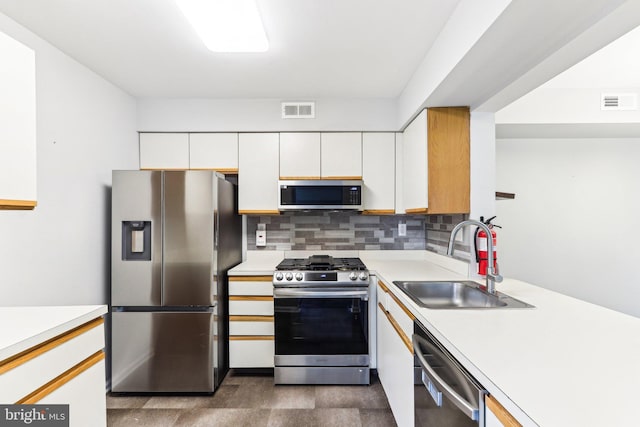 kitchen with white cabinetry, a sink, visible vents, stainless steel appliances, and light countertops