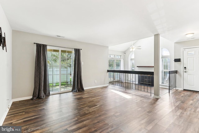 unfurnished living room featuring wood finished floors, visible vents, ceiling fan, and baseboards