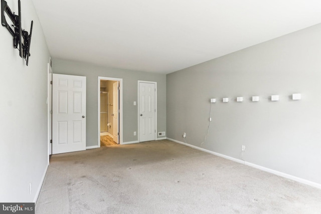 carpeted empty room featuring baseboards