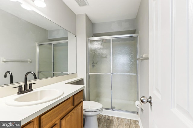 full bath with wood finished floors, visible vents, a shower stall, and vanity