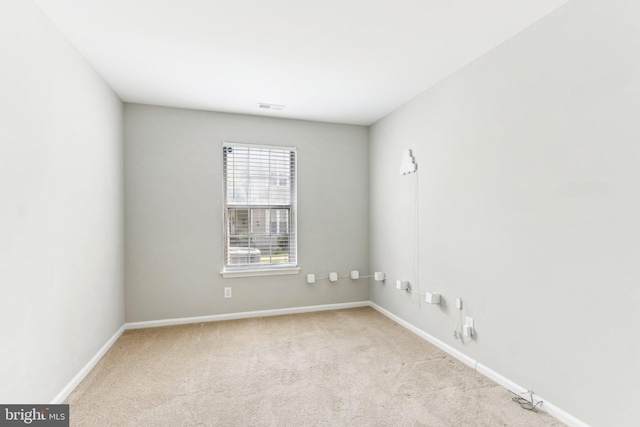 carpeted empty room featuring visible vents and baseboards