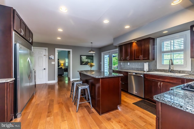 875 Brintons Bridge Rd, West Chester, PA 19382 - kitchen featuring light wood-style floors, a center island, a sink, appliances with stainless steel finishes, and backsplash