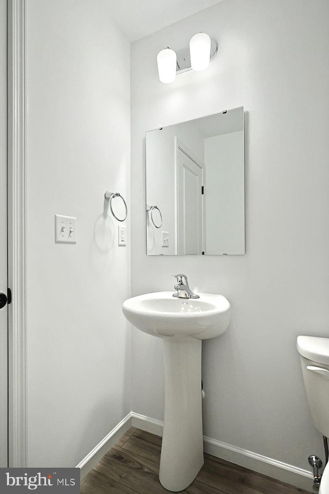 bathroom featuring baseboards, toilet, and wood finished floors