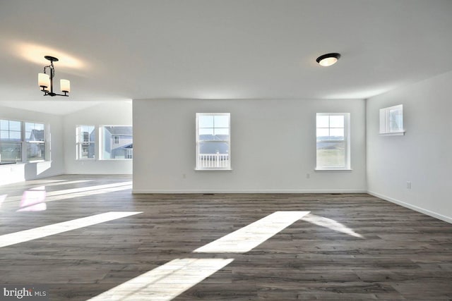 spare room featuring baseboards and wood finished floors