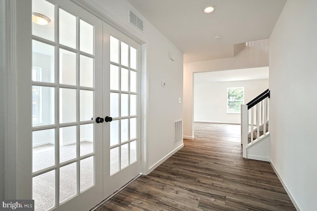 hallway featuring visible vents, baseboards, french doors, and dark wood-style floors