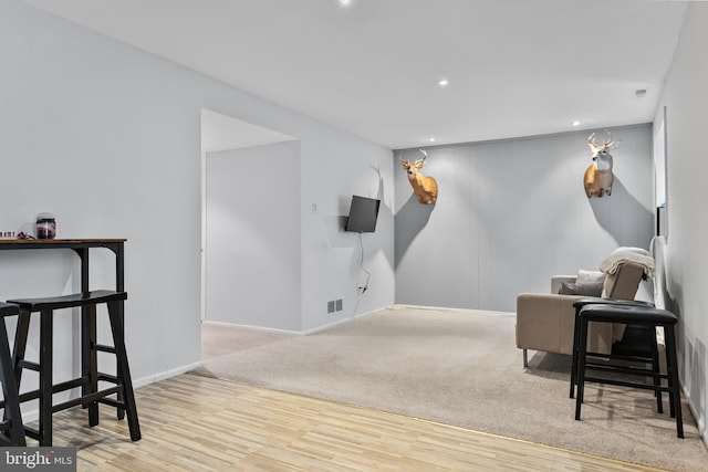 living area featuring visible vents, baseboards, recessed lighting, and wood finished floors