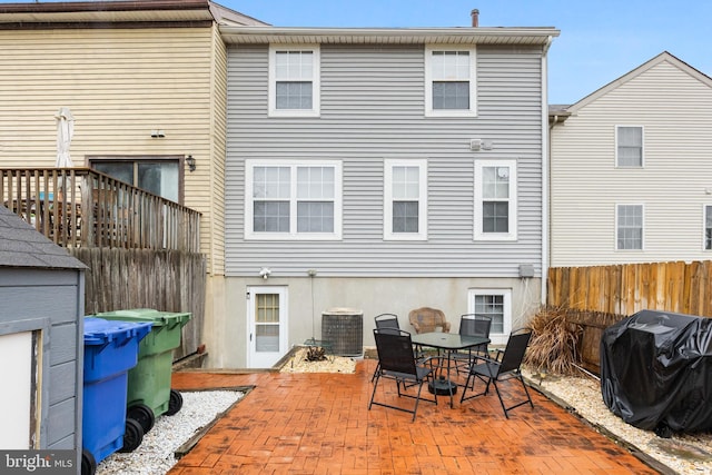 rear view of house featuring fence, cooling unit, and a patio