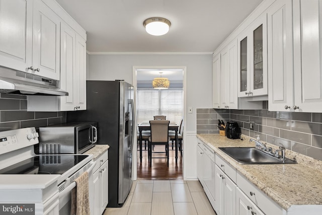 kitchen with a sink, stainless steel microwave, white cabinetry, and electric range