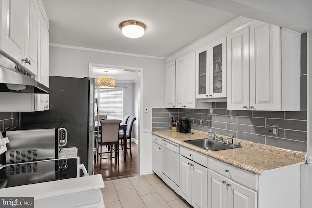 kitchen with white cabinets, dishwasher, under cabinet range hood, crown molding, and backsplash