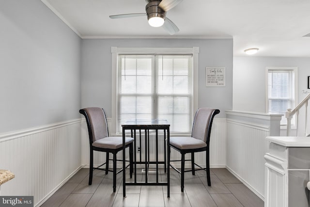 dining space featuring a ceiling fan, wainscoting, and wood finish floors