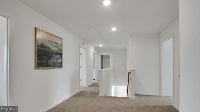 hall with an upstairs landing, recessed lighting, carpet flooring, baseboards, and visible vents