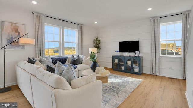 living area featuring baseboards, wood finished floors, and recessed lighting