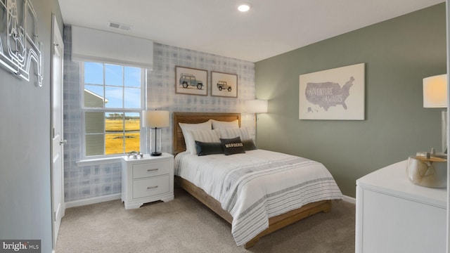 bedroom with wallpapered walls, baseboards, light colored carpet, and visible vents
