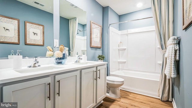 bathroom with a sink, visible vents, toilet, and wood finished floors