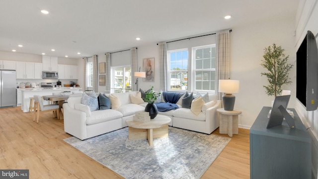 living area with light wood finished floors and recessed lighting