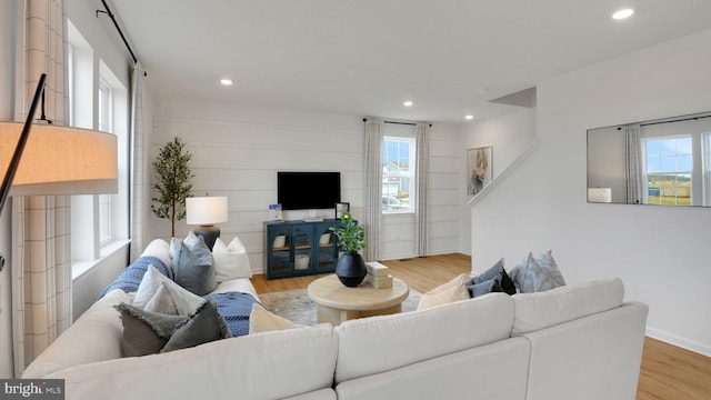 living area with baseboards, wood finished floors, and recessed lighting