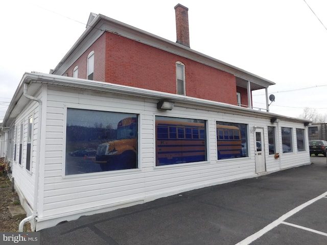 216 S Wayne St, Lewistown, PA 17044 - rear view of house featuring a chimney and brick siding