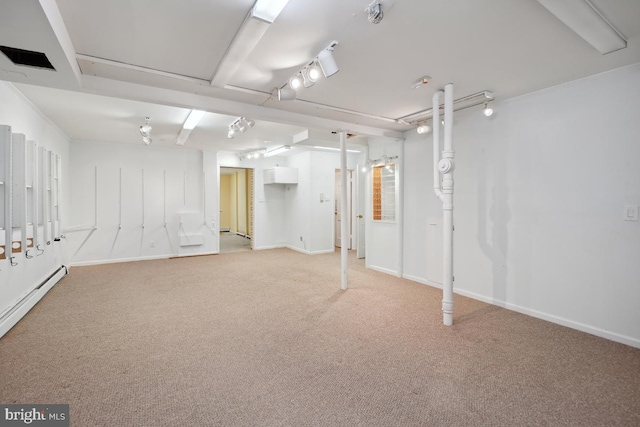 finished below grade area featuring baseboard heating, baseboards, and light carpet
