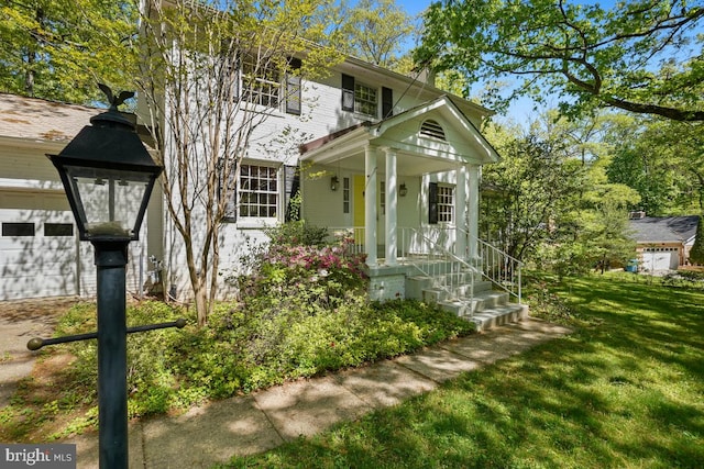 view of front of property featuring a porch, a garage, and a front yard