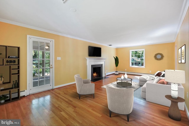 living area featuring crown molding, plenty of natural light, and wood finished floors