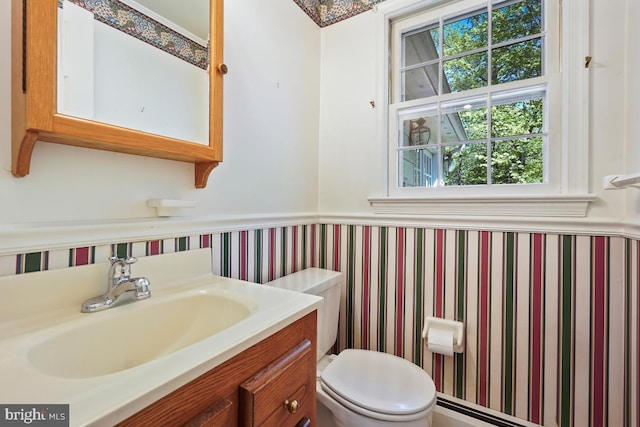 bathroom featuring toilet, a wainscoted wall, and vanity