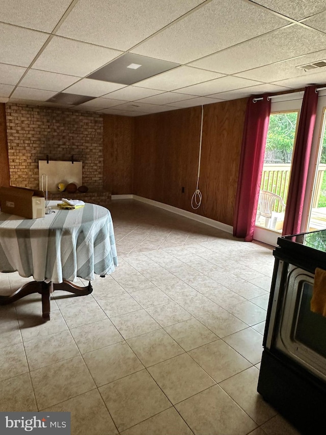 6112 Armor Dr, Clinton, MD 20735 - unfurnished living room featuring a drop ceiling, light tile patterned floors, and wood walls